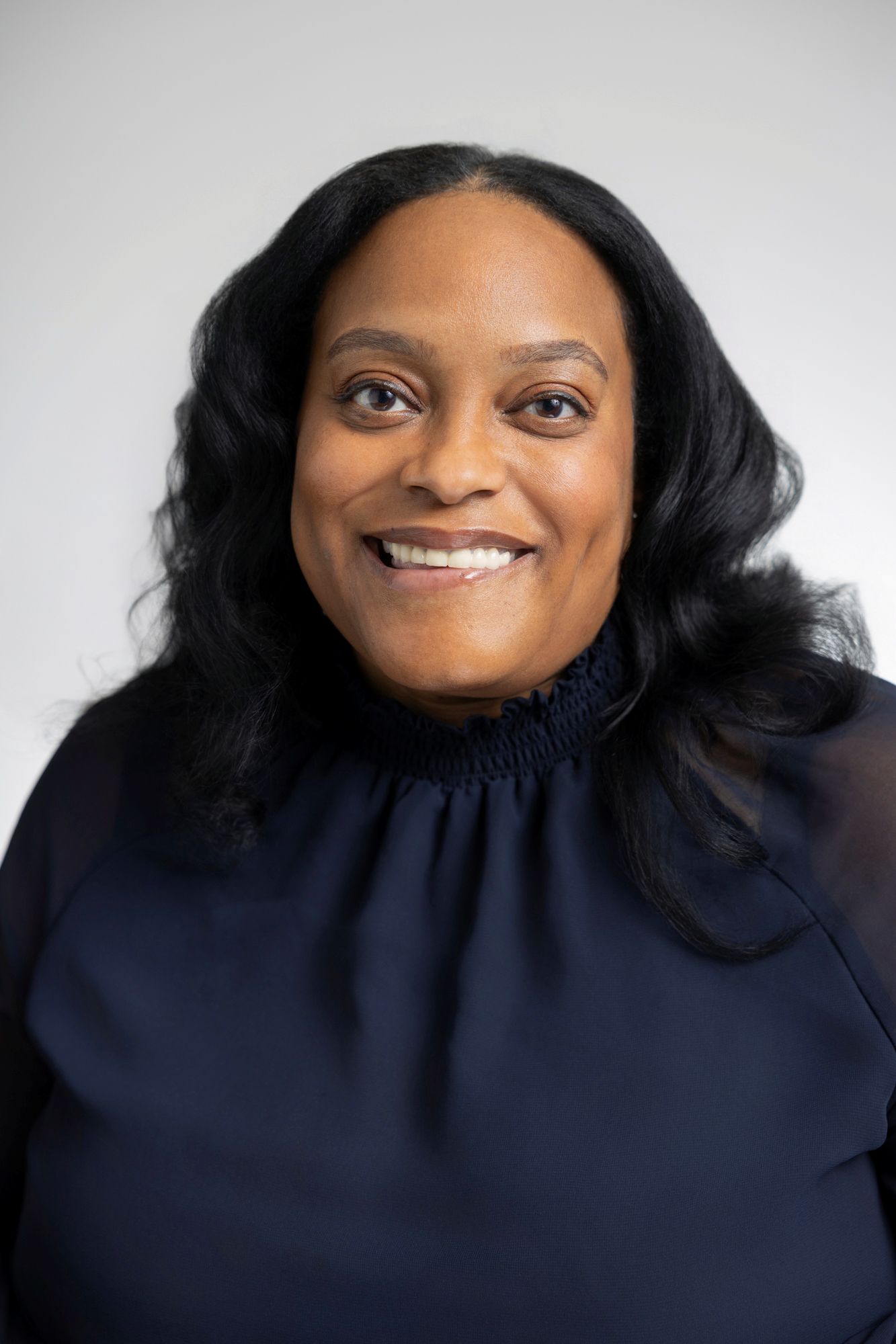 Woman smiling with blue high neck shirt