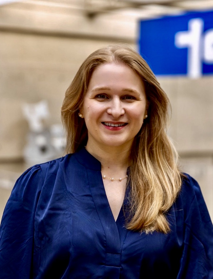 woman smiling with blue letter on banner